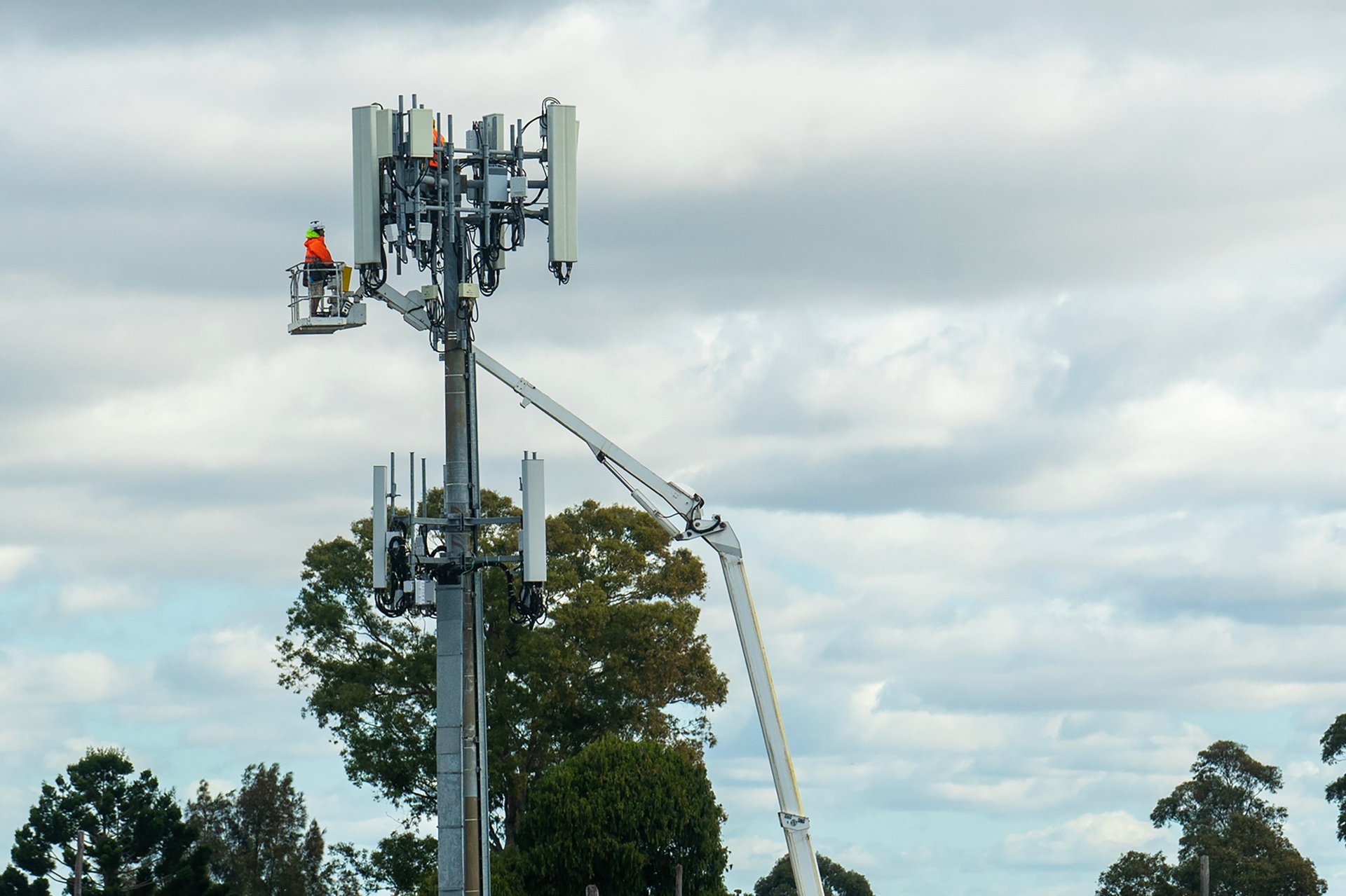 Worker performing maintenance on a 5g cellular tower, ensuring telecommunications infrastructure is functioning